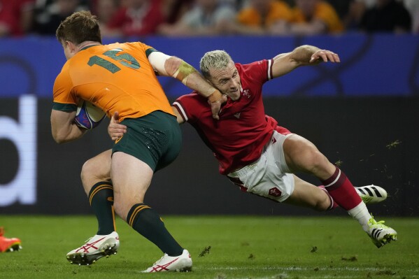 Wales' Gareth Davies, right, tackles Australia's Andrew Kellaway during the Rugby World Cup Pool C match between Wales and Australia at the OL Stadium in Lyon, France, Sunday, Sept. 24, 2023. (AP Photo/Christophe Ena)