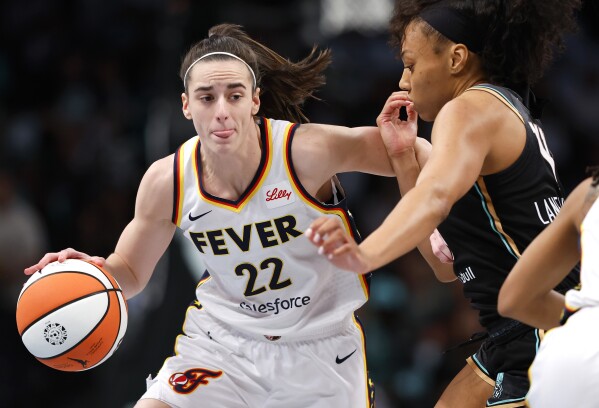 Indiana Fever guard Caitlin Clark (22) drives to the basket against New York Liberty forward Betnijah Laney-Hamilton (44) during the first half of a WNBA basketball game, Saturday, May 18, 2024, in New York. (AP Photo/Noah K. Murray)