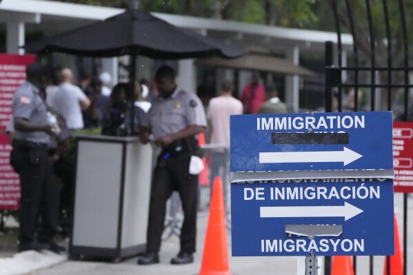 Officers stand outside the Immigration and Customs Enforcement (ICE) offices, Wednesday, July 26, 2023, in Miramar, Fla. (AP Photo/Wilfredo Lee)
