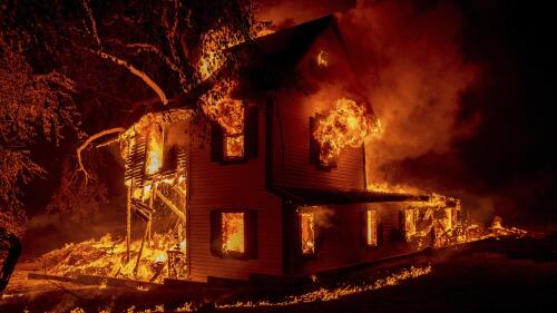 FILE - A home burns as the Dixie fire jumps Highway 395 south of Janesville, Calif., Aug. 16, 2021. Two insurance industry giants have pulled out of the California marketplace, saying that wildfire risk and the soaring cost of construction prompted them to stop writing new policies in the nation's most populous state. (AP Photo/Ethan Swope, File)