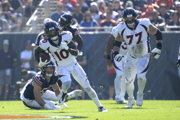 Denver Broncos wide receiver Jerry Jeudy (10) advances the ball off a reception from quarterback Russell Wilson during the first half of an NFL football game against the Chicago Bears Sunday, Oct. 1, 2023, in Chicago. (AP Photo/Nam Y. Huh)
