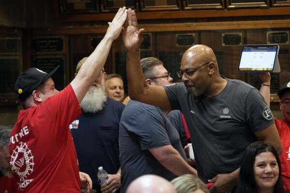 Volkswagen-autofabriekmedewerker Robert Crump, links, begroet collega Kelvin Allen terwijl ze de resultaten bekijken van een UAW-stemming, eind vrijdag 19 april 2024, in Chattanooga, Tennessee (AP Photo/George Walker IV)