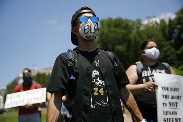 Protesters wear face masks to protect against the spread of the new coronavirus as they gather in Lafayette Square, Saturday, June 13, 2020, near the White House in Washington, while demonstrating against the death of George Floyd. (AP Photo/Patrick Semansky)