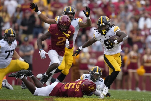 Iowa running back Jaziun Patterson (9) runs from Iowa State defensive back Myles Purchase (5) during the first half of an NCAA college football game, Saturday, Sept. 9, 2023, in Ames, Iowa. (AP Photo/Charlie Neibergall)