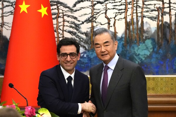 Chinese Foreign Minister Wang Yi, right, shakes hands with French Foreign Minister Stephane Sejourne, left, after a joint press conference at the Diaoyutai State Guesthouse in Beijing, China, Monday, April 1, 2024. (Ken Ishii/Pool Photo via AP)