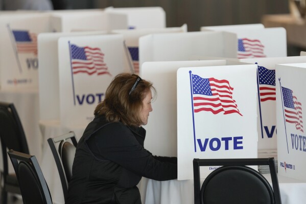 A voter fills out her ballot for the Michigan primary election in Grosse Pointe Farms, Mich., Tuesday, Feb. 27, 2024. Michigan is the last major primary state before Super Tuesday and a critical swing state in November's general election. (AP Photo/Paul Sancya)