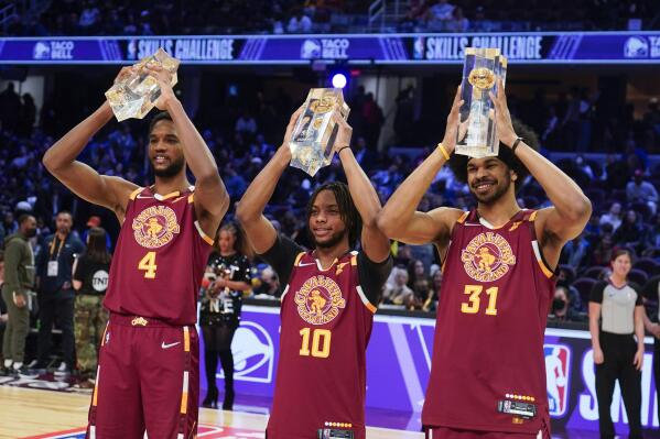 Cleveland Cavaliers' Darius Garland (10) celebrates with teammates Evan Mobley (4) and Jarrett Allen as they hold up their trophies after winning the team shooting part during the skills challenge competition, part of NBA All-Star basketball game weekend, Saturday, Feb. 19, 2022, in Cleveland. (AP Photo/Charles Krupa)