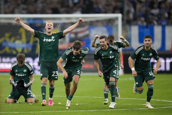 Panathinaikos players celebrate after scores the winning penalty in a penalty shootout at the end of the Champions League soccer match between Marseille and Panathinaikos at the Velodrome stadium in Marseille, southern France, Tuesday, Aug. 15, 2023. (AP Photo/Daniel Cole)