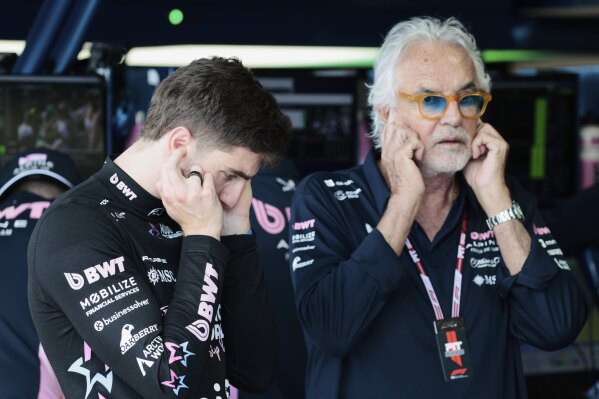 Alpine driver Jack Doohan of Australia and Flavio Briatore stand in the pit area before the qualifying session for the Formula One Miami Grand Prix auto race at the International Autodrome, Saturday, May 3, 2025, in Miami Gardens, Fla. (Shawn Thew/Pool Photo via AP)