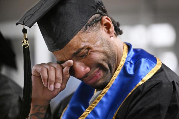 Future graduate Evan Holmes wipes his eyes after delivering a speech at the first-ever college graduation ceremony at MacDougall-Walker Correctional Institution, Friday, June 9, 2023, in Suffield, Conn. The ceremony was held under a partnership established in 2021 by the University of New Haven and the Yale Prison Education Initiative. (AP Photo/Jessica Hill)