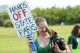 Bonnie, a seven-month-old dachshund, licks Alexandra Maxwell's face as they a protest against Gov. Ron DeSantis' plan to develop state parks with business ventures such as golf courses, pickleball courts and large hotels, during a demonstration at Oleta River State Park, Aug. 27, 2024, in North Miami Beach, Fla. (AP Photo/Wilfredo Lee, File)