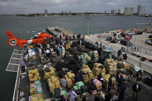 Journalists, politicians, and federal officials stand along with members of the U.S. Coast Guard and other law enforcement agencies, as they view more than one billion dollars worth of seized cocaine and marijuana aboard Coast Guard Cutter James at Port Everglades, Thursday, Feb. 17, 2022, in Fort Lauderdale, Fla. The Coast Guard said the haul included approximately 54,500 pounds of cocaine and 15,800 pounds of marijuana from multiple interdictions in the Caribbean Sea and the eastern Pacific. (AP Photo/Rebecca Blackwell)