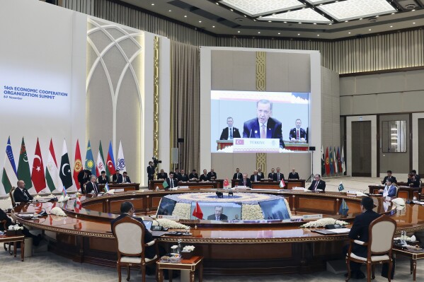 In this handout photo released by Turkish Presidency, Turkey's President Recep Tayyip Erdogan, background center, talks during a meeting of the 10-member Economic Cooperation Organization in Tashkent, Uzbekistan, Thursday, Nov. 9, 2023. (Turkish Presidency via AP)