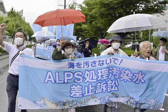 A group of plaintiffs and supporters, demanding revokation of TEPCO's treated water discharge plan, head to the Fukushima District Court to file a lawsuit, in Fukushima, northeastern Japan, Friday, Sept. 8, 2023. Fishermen and residents of Fukushima and five other prefectures along Japan’s northeastern coast filed a lawsuit Friday demanding a halt to the ongoing release of treated radioactive wastewater from the wrecked Fukushima nuclear plant into the sea. The banner reads "Lawsuit to halt the release of ALPS treated radioactive wastewater."(Kyodo News via AP)
