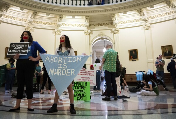 FILE - Sarah Zarr, left, from Students for Life of America, and Melanie Salazar, from the Progressive Anti-Abortion Uprising, stand inside the Texas State Capitol Rotunda to protest an International Women's Day Sit-In for Abortion Rights, Wednesday, March 8, 2023, in Austin, Texas. The state of abortion access in the U.S. remains in flux with an accusation against Planned Parenthood in Missouri and a plan to educate doctors headed to the governor in South Dakota. (Sara Diggins/Austin American-Statesman via AP, File)