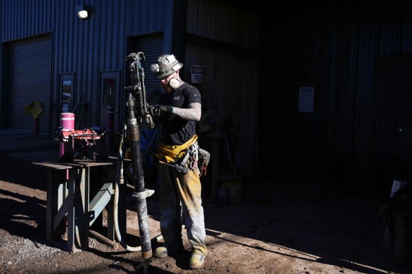 A woker checks on a piece of mining equipment at the Energy Fuels Inc. uranium Pinyon Plain Mine Wednesday, Jan. 31, 2024, near Tusayan, Ariz. (AP Photo/Ross D. Franklin)