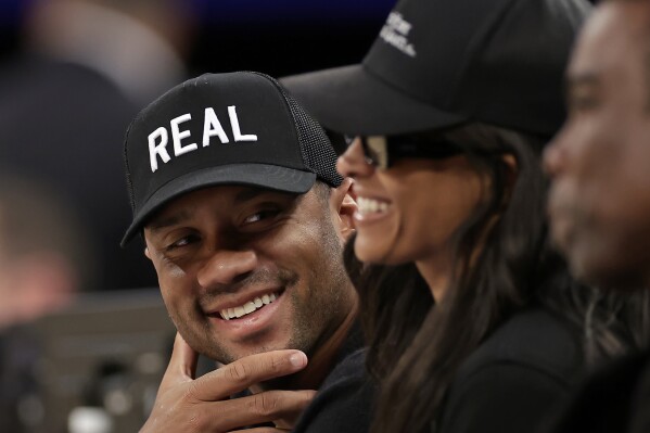 New York Giants quarterback Russell Wilson smiles with his wife Ciara during the second half of an NBA basketball game between the LA Clippers and the New York Knicks Wednesday, March 26, 2025, in New York. (AP Photo/Adam Hunger)