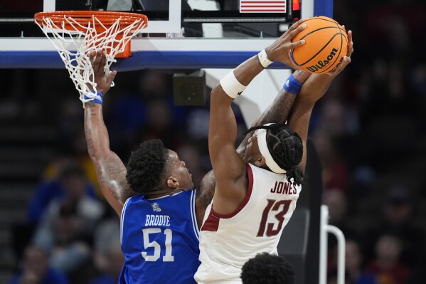 Washington State's Isaac Jones (13) is fouled on his way to the basket by Drake's Darnell Brodie (51) during the second half of a first-round college basketball game in the NCAA Tournament Thursday, March 21, 2024, in Omaha, Neb. (AP Photo/Charlie Neibergall)