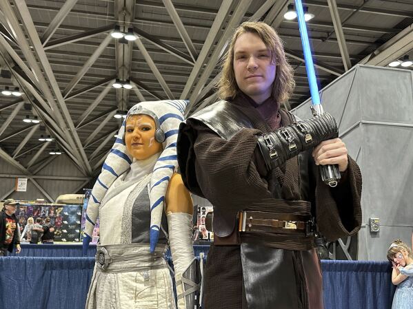 Courtney, left and Josh Thornton from Tulsa, Okla. dressed as Ahsoka Tano and Anakin Skywalker from the Star Wars franchise attend the 25th annual Planet Comicon Kansas City on Friday, March 8, 2024 in Kansas City, Mo.. Planet Comicon Kansas City is a weekend long event featuring cosplayers, artists, celebrity guests, comic book creators and more for fans of all areas of pop culture. (AP Photo/Nick Ingram)