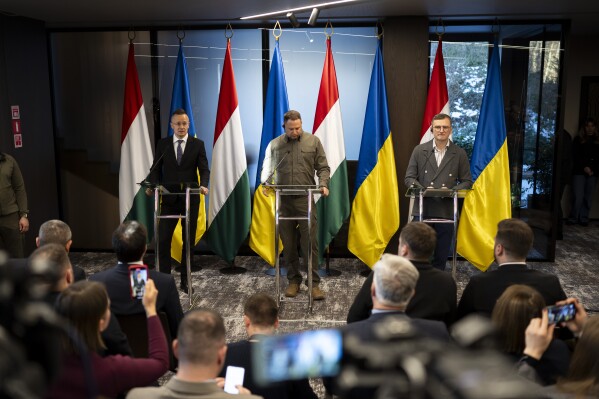 Hungary's foreign minister Peter Szijjarto (left) speaks during a press conference with his Ukrainian counterpart Dmytro Kuleba (right) and head of Ukrainian Presidental Office Andriy Yermak in Kamianytsia, Ukraine, Monday Jan. 29, 2024. The meeting between the foreign ministers of Ukraine and Hungary comes as Budapest has obstructed European Union efforts to provide financial and military assistance to Ukraine to use in its war against Russia. (AP Photo/Denes Erdos)