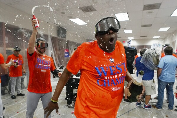 Houston Astros manager Dusty Baker Jr., right, celebrates with coach Jason Kanzler, left, in the locker room after clinching the AL West title after a baseball game against the Arizona Diamondbacks, Sunday, Oct. 1, 2023, in Phoenix. (AP Photo/Ross D. Franklin)