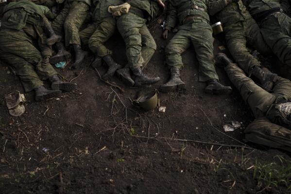The bodies of 11 Russian soldiers lie on the ground in the village of Vilkhivka, recently retaken by Ukrainian forces near Kharkiv, Ukraine, Monday, May 9, 2022. (AP Photo/Felipe Dana)