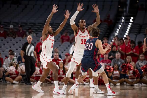 Houston guard Marcus Sasser (0) and forward Reggie Chaney (32) defend against Saint Mary's guard Aidan Mahaney (20) during the first half of an NCAA college basketball game in Fort Worth, Texas, Saturday, Dec. 3, 2022. (AP Photo/Emil Lippe)