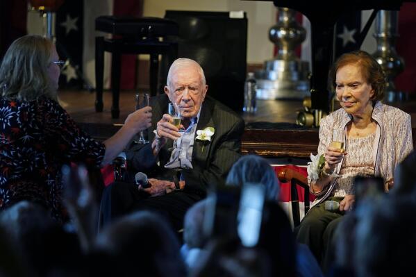 Amy Carter, left, rises her glass during a toast to her parents former President Jimmy Carter and former first lady Rosalynn Carter during a reception to celebrate their 75th wedding anniversary Saturday, July 10, 2021, in Plains, Ga.. (AP Photo/John Bazemore, Pool)
