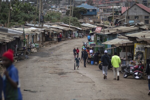 FILE - People walk down a street in Kibera neighborhood, a stronghold of presidential candidate Raila Odinga, in Nairobi, Kenya, on Aug. 11, 2022. A nationwide power blackout hit Kenya Sunday evening, Dec. 11, 2023, paralyzing large parts of the country, including the main airport in the capital, Nairobi, a major transport hub connecting East Africa to Asia, Europe and other parts of the world. (AP Photo/Mosa'ab Elshamy, File)