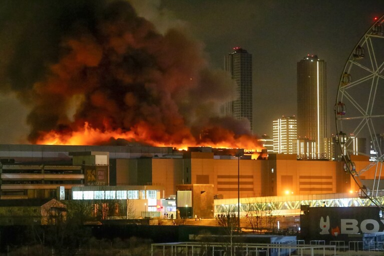 A massive blaze is seen over the Crocus City Hall on the western edge of Moscow, Russia, Friday, March 22, 2024. Several gunmen have burst into a big concert hall in Moscow and fired automatic weapons at the crowd, injuring an unspecified number of people and setting a massive blaze in an attack days after President Vladimir Putin cemented his grip on the country in a highly orchestrated electoral landslide. (Sergei Vedyashkin/Moscow News Agency via AP)