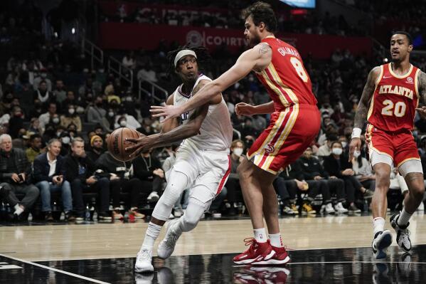 Los Angeles Clippers' Terance Mann, left, is defended by Atlanta Hawks' Danilo Gallinari during second half of an NBA basketball game Sunday, Jan. 9, 2022, in Los Angeles. (AP Photo/Jae C. Hong)