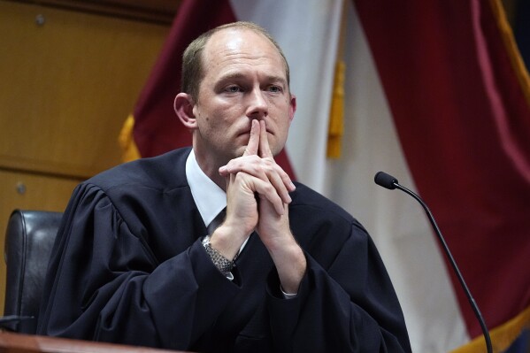 FILE - Fulton County Superior Judge Scott McAfee presides in court, Feb. 27, 2024, in Atlanta. Lawyers for former President Donald Trump argued in a court filing that the charges against him in the Georgia election interference case seek to criminalize political speech and advocacy conduct that is protected by the First Amendment. Fulton County Superior Court Judge Scott McAfee plans to hear arguments on that filing and on two pretrial motions filed by former Georgia Republican Party chair David Shafer during a hearing set for Thursday. (AP Photo/Brynn Anderson, Pool, File)