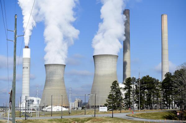 FILE - Georgia Power Co.'s Plant Bowen releases steam as it generates electricity from burning coal on Monday, Dec. 14, 2020, in Euharlee, Ga. The electric utility and regulatory staff agreed to a deal on Wednesday, Dec. 14, 2022 to raise rates by $1.8 billion over three years starting in January. (AP Photo/Mike Stewart, File)