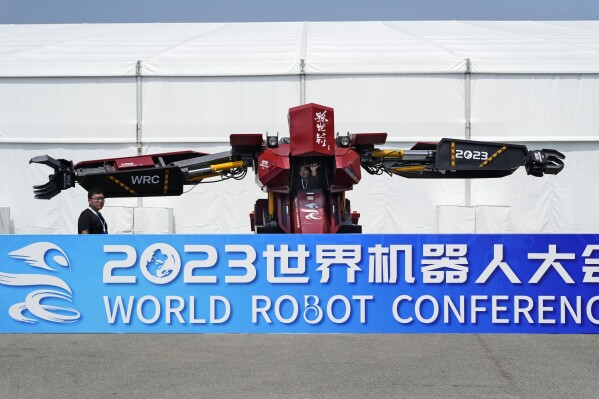 Workers demonstrate a giant robot at the annual World Robot Conference at the Beijing Etrong International Exhibition and Convention Center, Wednesday, Aug. 16, 2023. (AP Photo/Ng Han Guan)