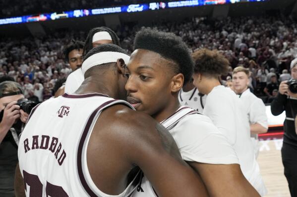 Texas A&M guards Tyrece Radford, left, and Wade Taylor IV, right, hug after a 67-61 win over Alabama in an NCAA college basketball game Saturday, March 4, 2023, in College Station, Texas. (AP Photo/Sam Craft)