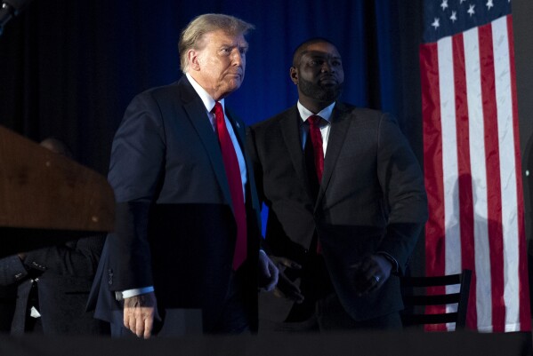 Republican presidential candidate former President Donald Trump, accompanied Rep. Byron Donalds, R-Fla., right, arrives at the Black Conservative Federation's Annual BCF Honors Gala at the Columbia Metropolitan Convention Center in Columbia, S.C., Friday, Feb. 23, 2024. (AP Photo/Andrew Harnik)