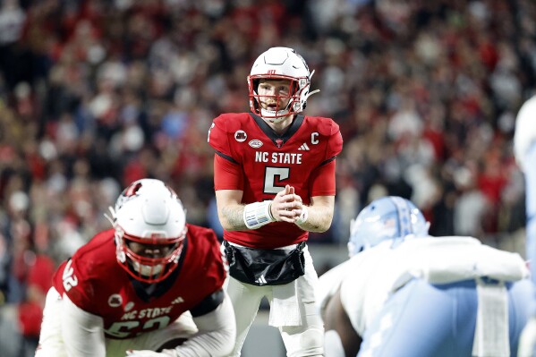 FILE - North Carolina State quarterback Brennan Armstrong (5) surveys' the defense against North Carolina during the first half of an NCAA college football game in Raleigh, N.C., Saturday, Nov. 25, 2023. No. 19 North Carolina State and Kansas State completed strong seasons this year to earn a trip to the Pop-Tarts Bowl,(AP Photo/Karl B DeBlaker, File)