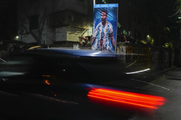 A car passes a poster of Argentina's Leonel Messi, erected by the Indian fans of Argentina during the World Cup semi final soccer match between Argentina and Croatia in Qatar, Wednesday, Dec. 14, 2022. Argentina defeated Croatia 3-0. (AP Photo/Bikas Das)