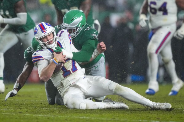 O quarterback do Buffalo Bills, Josh Allen, é demitido pelo lado defensivo do Philadelphia Eagles, Brandon Graham, durante a primeira metade de um jogo de futebol americano da NFL no domingo, 26 de novembro de 2023, na Filadélfia.  (Foto AP/Matt Rourke)
