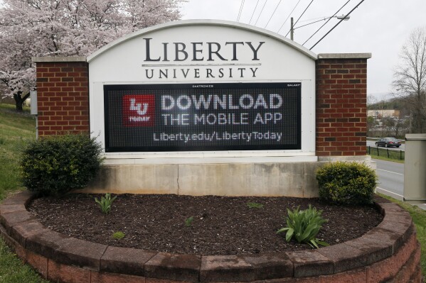 FILE - A sign marks the entrance to Liberty University, March 24, 2020, in Lynchburg, Va. Liberty University has agreed to pay an unprecedented $14 million fine after the Christian school failed to disclose information about crimes that occurred on its Lynchburg campus, including those involving sexual assaults, the U.S. Department of Education announced Tuesday, March 5, 2024. (AP Photo/Steve Helber, File)