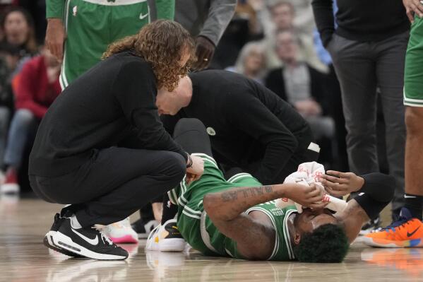 Trainers tend to Boston Celtics guard Marcus Smart after an injury during first-half NBA basketball game action against the Toronto Raptors in Toronto, Saturday, Jan. 21, 2023. (Frank Gunn/The Canadian Press via AP)