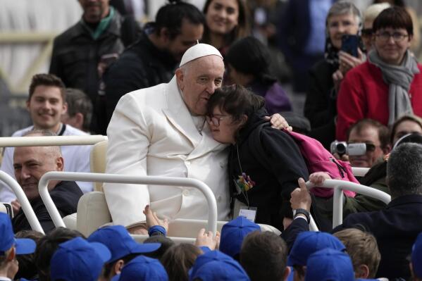 Pope Francis hugs a child at the end of his weekly general audience in St. Peter's Square, at the Vatican, Wednesday, March 29, 2023. (AP Photo/Alessandra Tarantino)