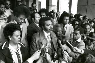 FILE - Massachusetts state Sen. Bill Owens, D-Boston, center, speaks during a news conference on City Hall Plaza, in Boston, April 6, 1976, the day after the assault on Ted Landsmark at an anti-busing demonstration. Owens, the first Black state senator in Massachusetts who fought for racial justice and economic equality, and was one of the first to call for reparations for the descendants of Black slaves, died Saturday, Jan. 22, 2022, his family said in a statement. He was 84. (Ted Dully/The Boston Globe via AP, File)