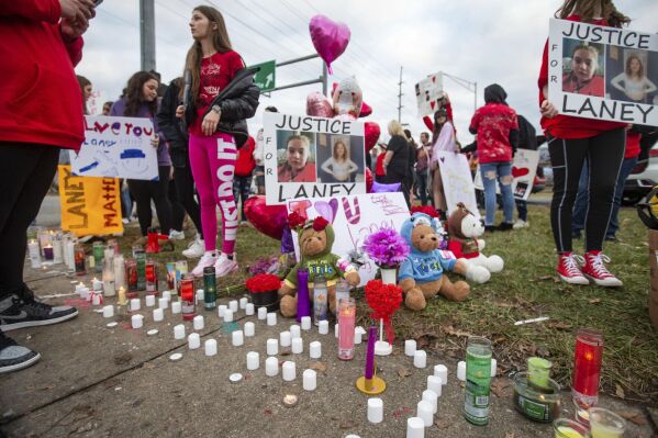 FILE - People gather at the intersection of 5th Avenue and 31st Street (U.S. 60) in Huntington, W.Va., Jan. 1, 2023, for a candlelight vigil after a 13-year-old girl was struck and killed there days earlier by a vehicle driven by an off-duty Cabell County sheriff's deputy. On Monday, Sept. 25, the family of the 13-year-old who was struck and killed filed a civil suit in federal court against the now-resigned officer and other county officials. Opal Slone, the mother of Jacqueline “Laney” Hudson, is requesting a jury trial against former Cabell County Sheriff’s Deputy Jeffrey Racer, accusing him of speeding when he fatally struck her daughter in December 2022 with his marked cruiser, among other allegations. (Ryan Fischer/The Herald-Dispatch via AP, File)