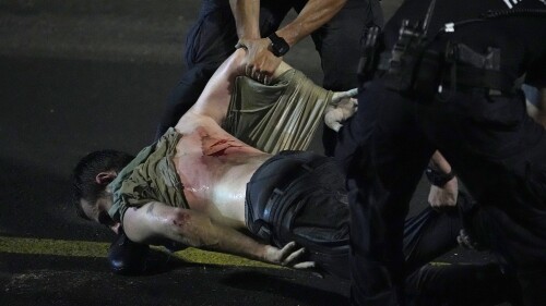 An injured demonstrator is dragged by police to be detained during a protest against plans by Netanyahu's government to overhaul the judicial system, in Tel Aviv, Monday, July 24, 2023. Israeli lawmakers on Monday approved a key portion of Prime Minister Benjamin Netanyahu's divisive plan to reshape the country's justice system despite massive protests that have exposed unprecedented fissures in Israeli society. (AP Photo/Ariel Schalit)