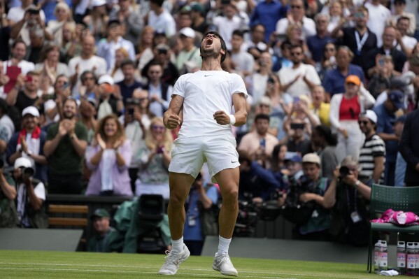 Spain's Carlos Alcaraz celebrates after beating Denmark's Holger Rune to win their men's singles match on day ten of the Wimbledon tennis championships in London, Wednesday, July 12, 2023. (AP Photo/Kirsty Wigglesworth)
