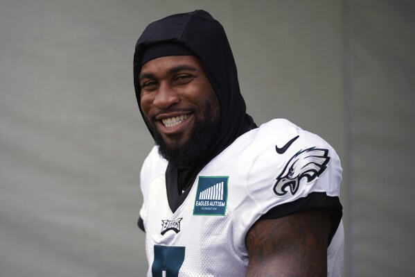 FILE - Philadelphia Eagles' Haason Reddick smiles as he walks onto the field during the NFL football team's training camp, Thursday, Aug. 3, 2023, in Philadelphia. Reddick hasn't missed a game in his first six seasons, so the Pro Bowl edge rusher won't let thumb surgery keep him off the field. Reddick will line up Sunday and go after Mac Jones when the Philadelphia Eagles visit the New England Patriots. (AP Photo/Matt Slocum, File)