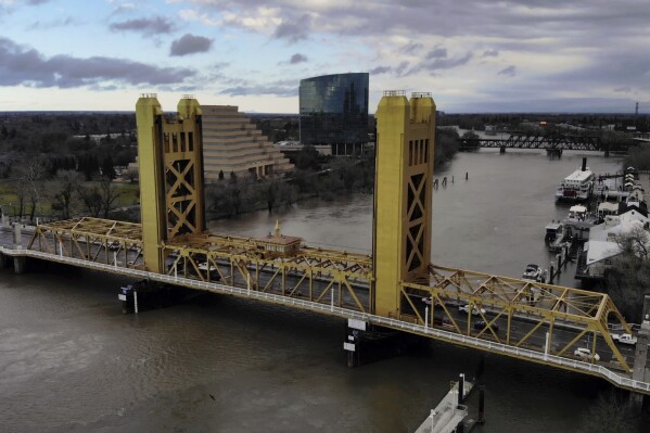 FILE - The Sacramento River flows under the Tower Bridge in Sacramento, Calif., on Feb. 14, 2019. On Friday, Dec. 8, 2023, California Gov. Gavin Newsom's administration released the final environmental impact report for a project to build a tunnel to transport water from Northern California to Southern California. (Hector Amezcua/The Sacramento Bee via AP, File)