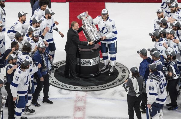 FILE - In this Sept. 28, 2020, file photo, Tampa Bay Lightning's Steven Stamkos (91) is presented the Stanley Cup from NHL commissioner Gary Bettman as they celebrate after defeating the Dallas Stars in the NHL Stanley Cup hockey finals in Edmonton, Alberta. The NHL is embarking on a 56-game regular season with all divisional play in a knock-down, drag-out battle for the Stanley Cup unlike any other in hockey history.  (Jason Franson/The Canadian Press via AP, File)