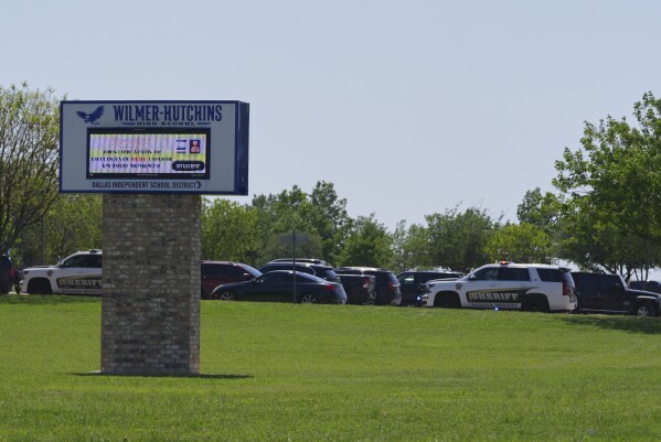 Sheriff vehicles sit parked in a lot at Wilmer-Hutchins High School, where police are responding to reports of a shooting in Dallas, Tx., Tuesday, April 15, 2025. (AP Photo/Julio Cortez)